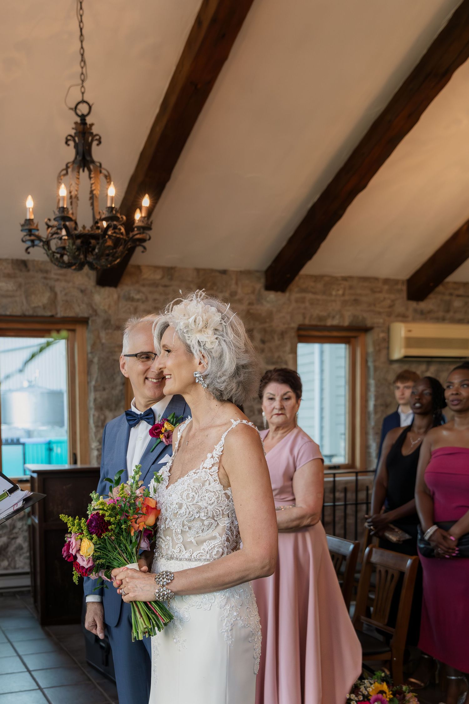 Groom steals a glance at his bride before the ceremony begins in the Carriage House at Vineland Estates Winery.