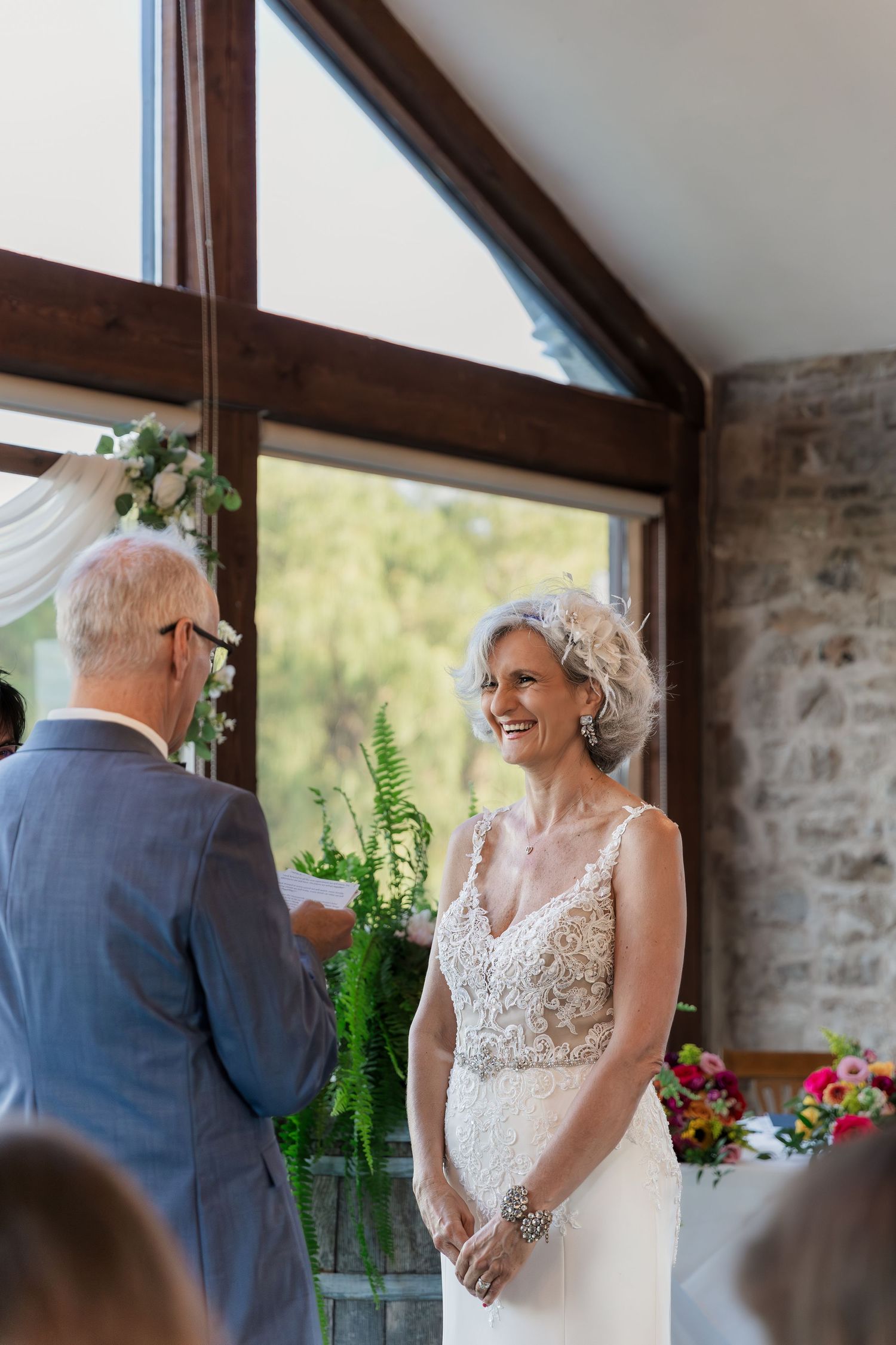Bride enjoying the groom reading his vows during their wedding ceremony in the Carriage House at Vineland Estates Winery.