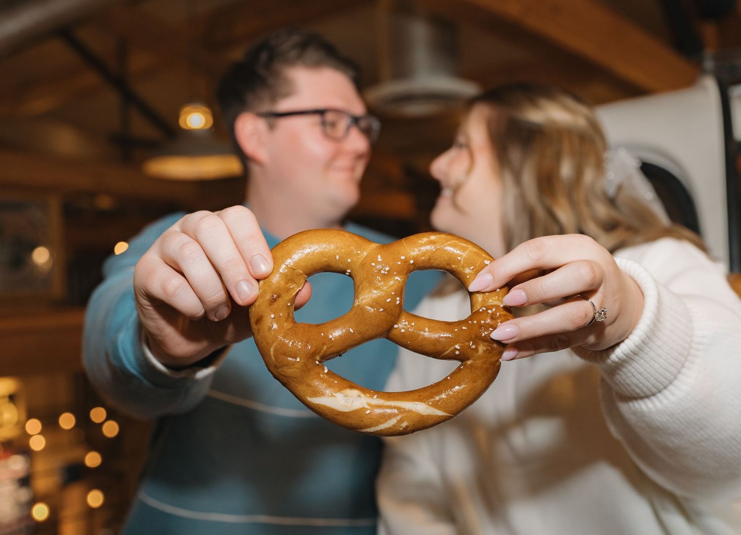 A sequence of photos showing hands breaking apart a soft baked pretzel in a dimly lit restaurant setting. Leavenworth, WA