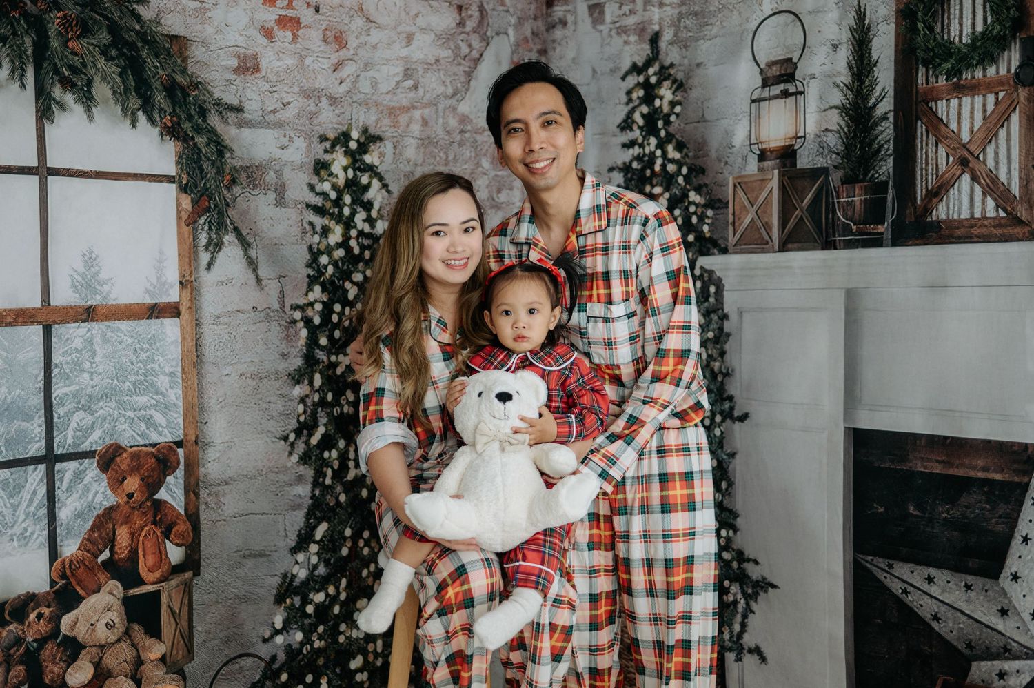 A collection of holiday family portraits in front of a rustic brick wall with festive greenery and decor.