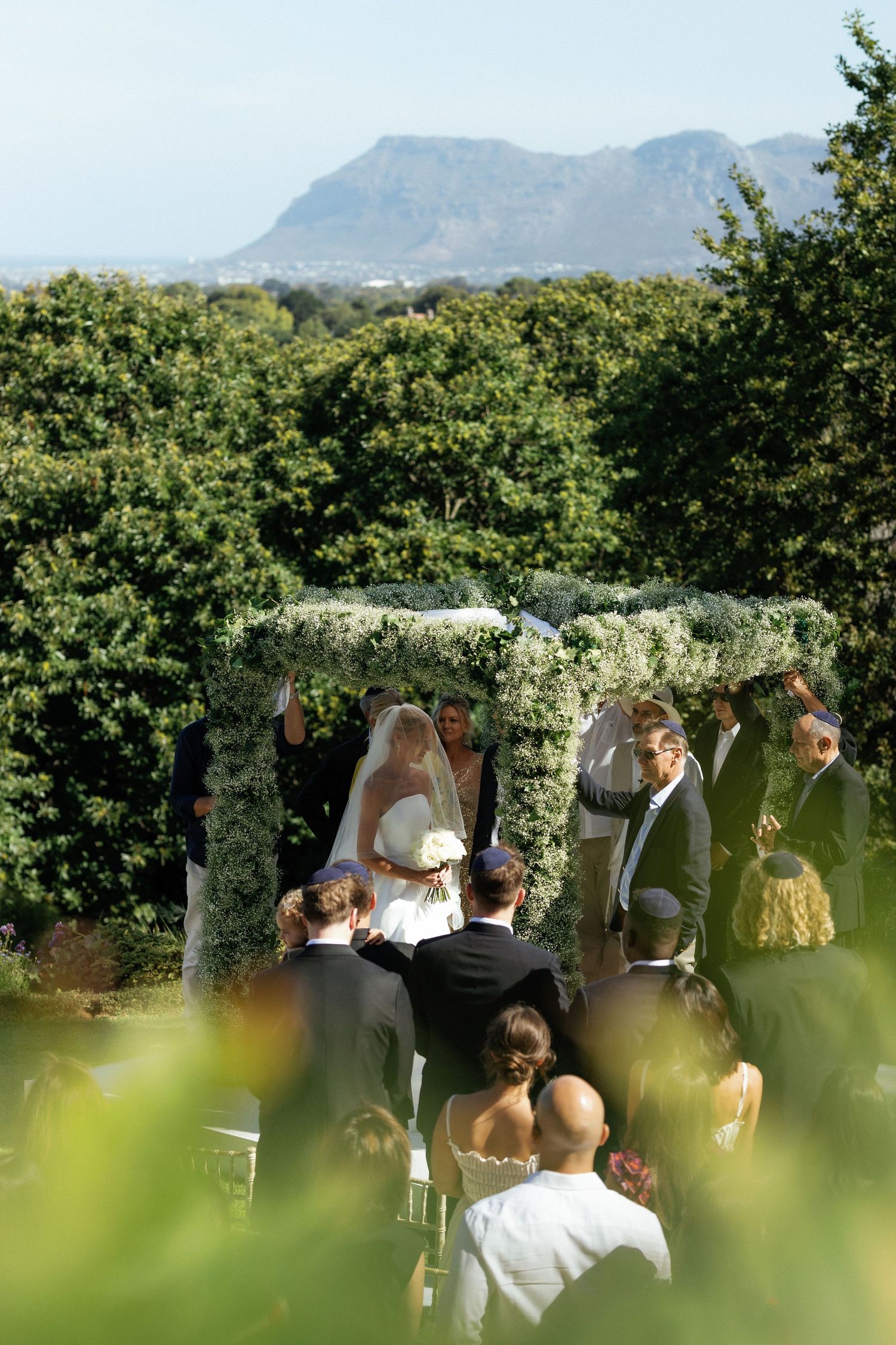 An outdoor wedding ceremony setup with mountain views and lush greenery in the background.