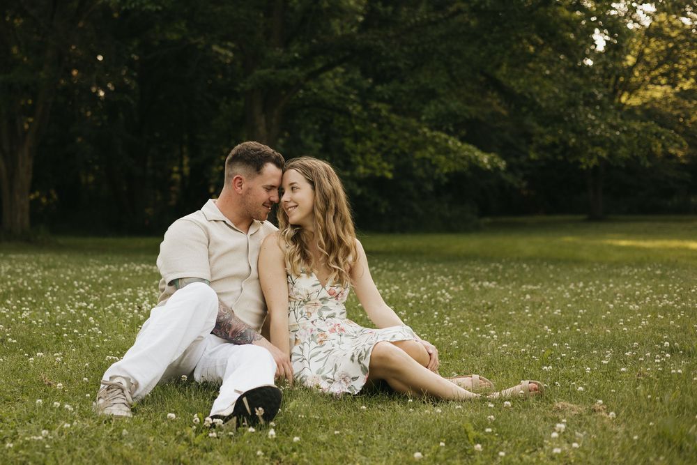 Romantic couple shares tender moments in a sunlit garden setting during a photo session.