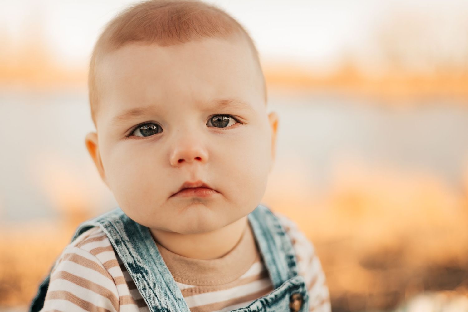 baby in denim overalls and striped shirt with a curious expression | Westminster, CO motherhood & family photographer