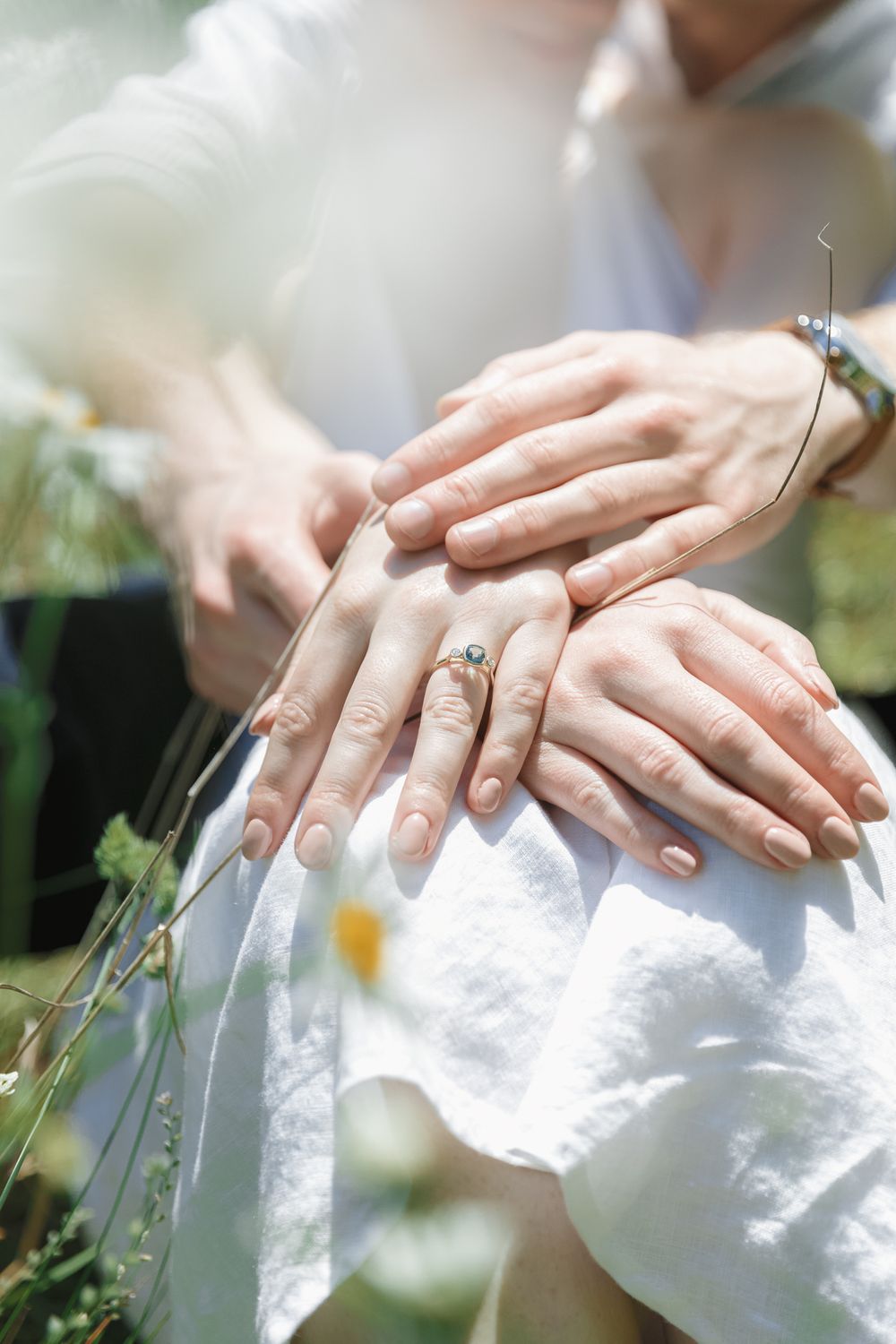 A couple holding hands in a field of wild flowers at a Vancouver Island engagement session.
