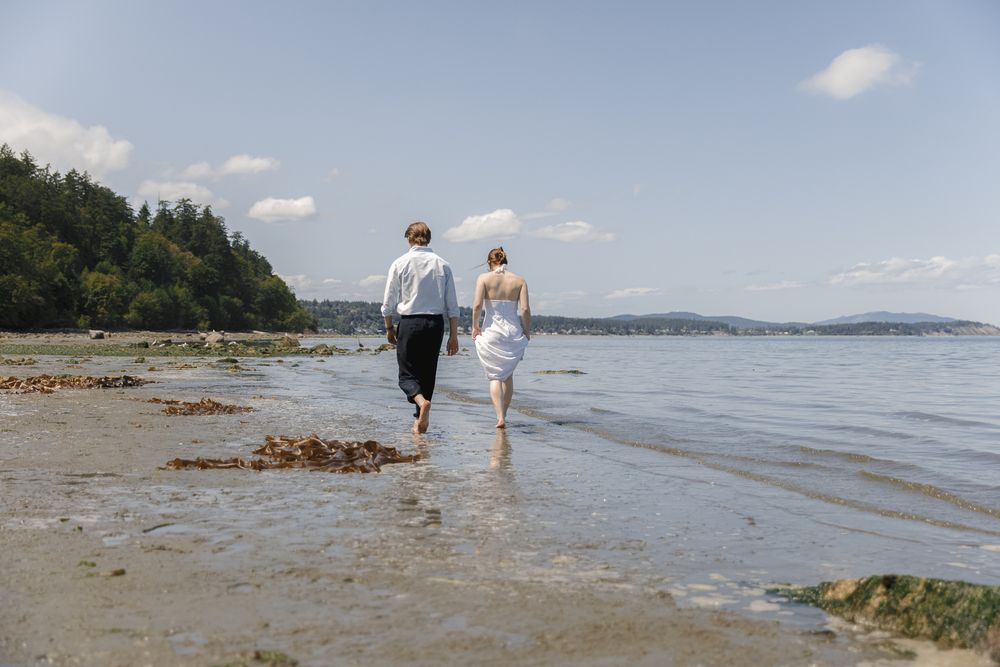 A couple walking along the beach on Vancouver Island during an engagement session, taken by Kristina Harnett.