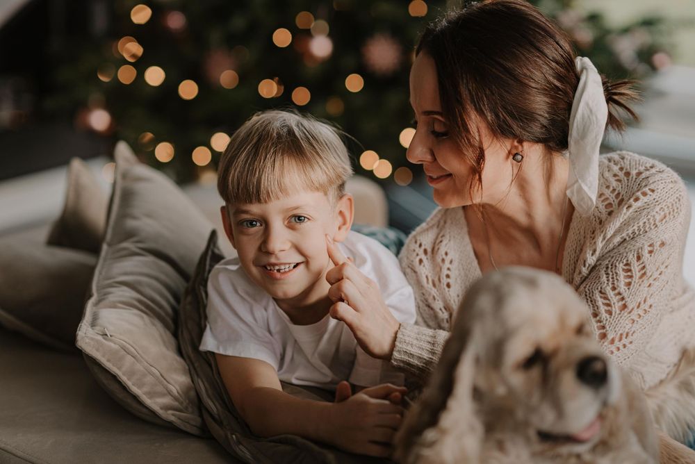 A cozy indoor photoshoot featuring intimate moments between a couple and their dog in warm lighting.