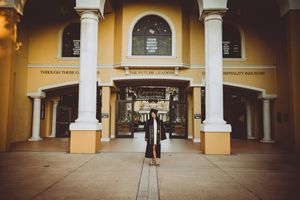 Spanish colonial style building exterior with arched walkways and yellow walls.