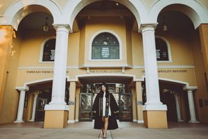 Wide angle shot of an elegant colonnade with arched walkways and yellow stucco walls.
