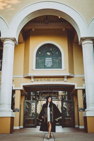 Mediterranean style building entrance with cream walls and white columns framing glass doors.