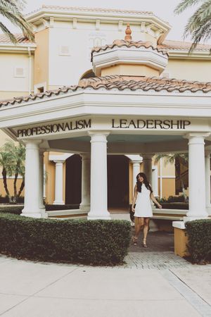 Mediterranean-style building exterior with white columns and archways displaying 'Professionalism Leadership' signage.