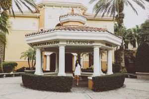 Mediterranean architecture building exterior with palm trees and cream colored walls.