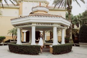 Wide angle view of a Spanish colonial style retail building with landscaped gardens.