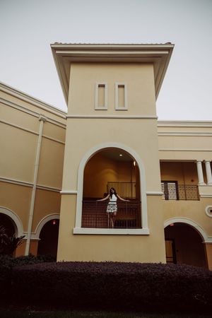 Architectural view of a beige Mediterranean-style building with arched windows and tower.