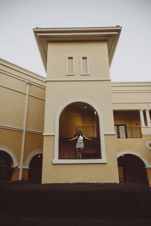 Architectural photo of cream colored tower with arched window opening.
