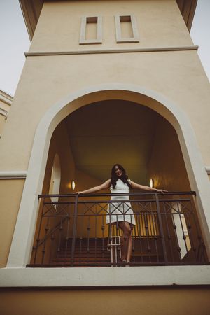 Creative photo sequence on a balcony of a Spanish colonial style building.