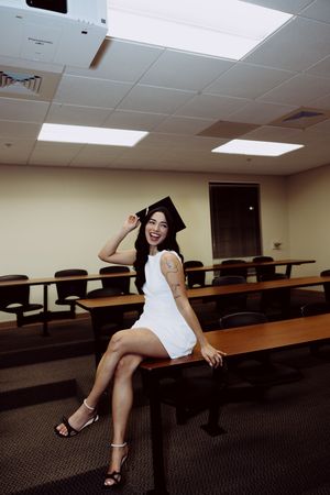 Empty lecture hall with curved rows of desks and beige walls.