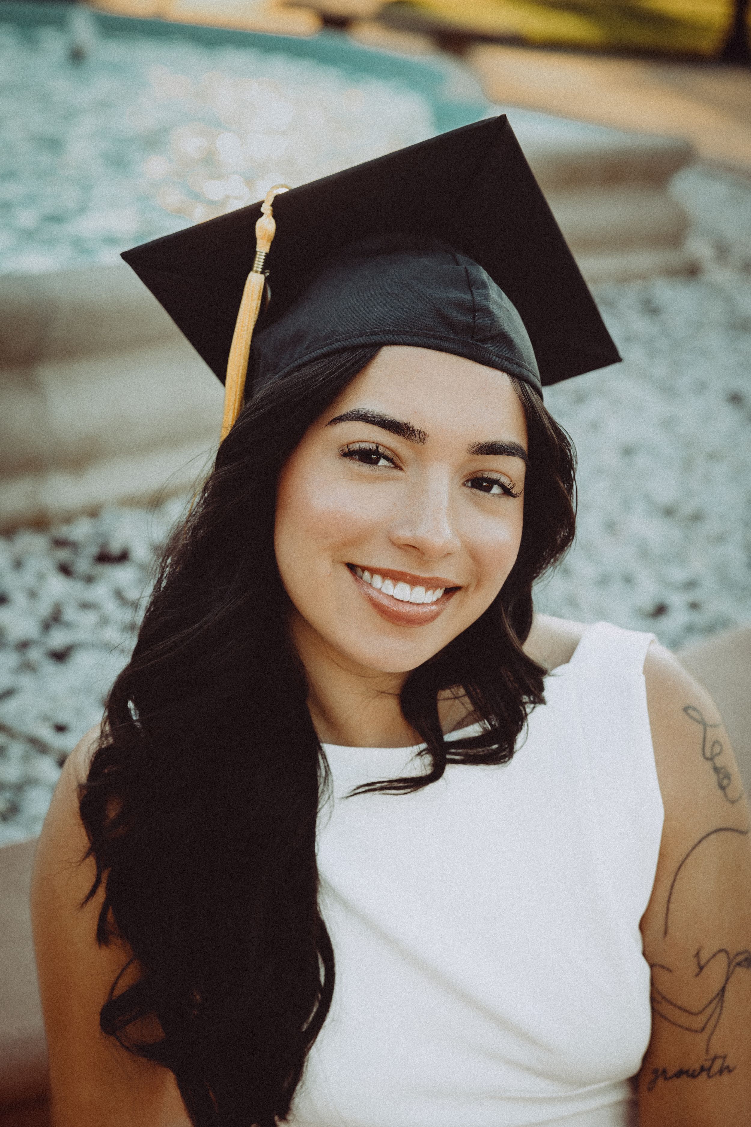 Close-up graduation portraits featuring a black cap and gown against a soft blue background.