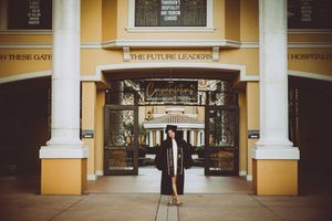 Architectural panorama of a historic shopping arcade with yellow walls and white columns in warm lighting.