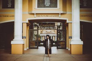 Interior view of an elegant shopping gallery with classical columns and yellow-painted walls in vintage style.