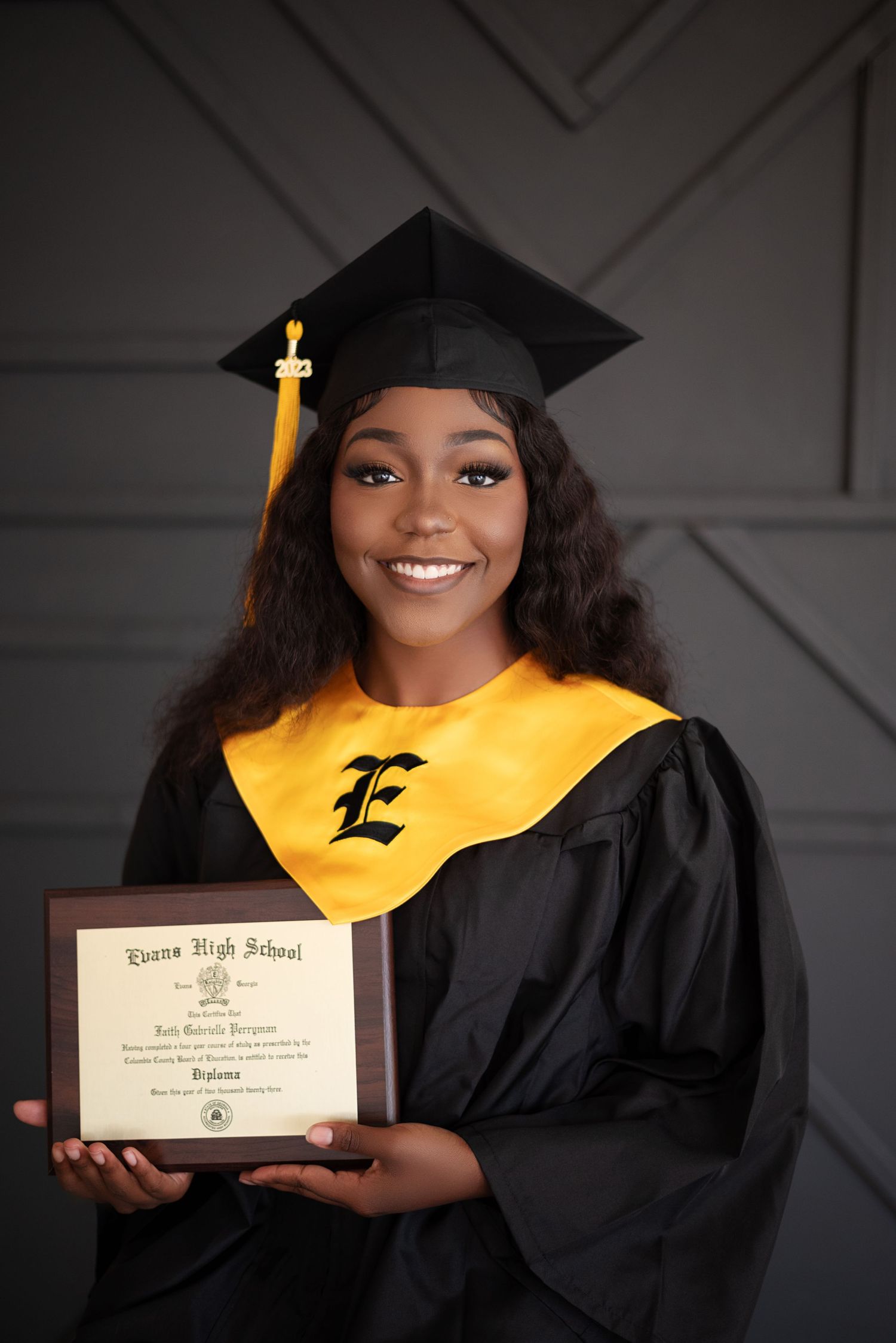 Graduate in black cap and gown poses with diploma in series of celebratory graduation photos.