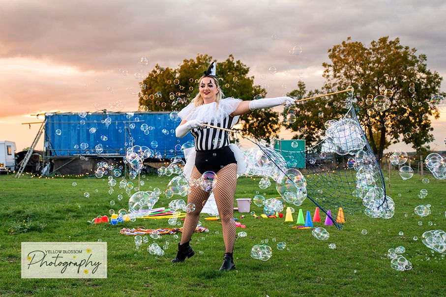 People playing bubble soccer in an outdoor field at sunset with inflatable zorb balls.