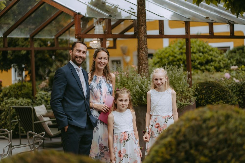 Family portrait in garden setting with floral dresses.
