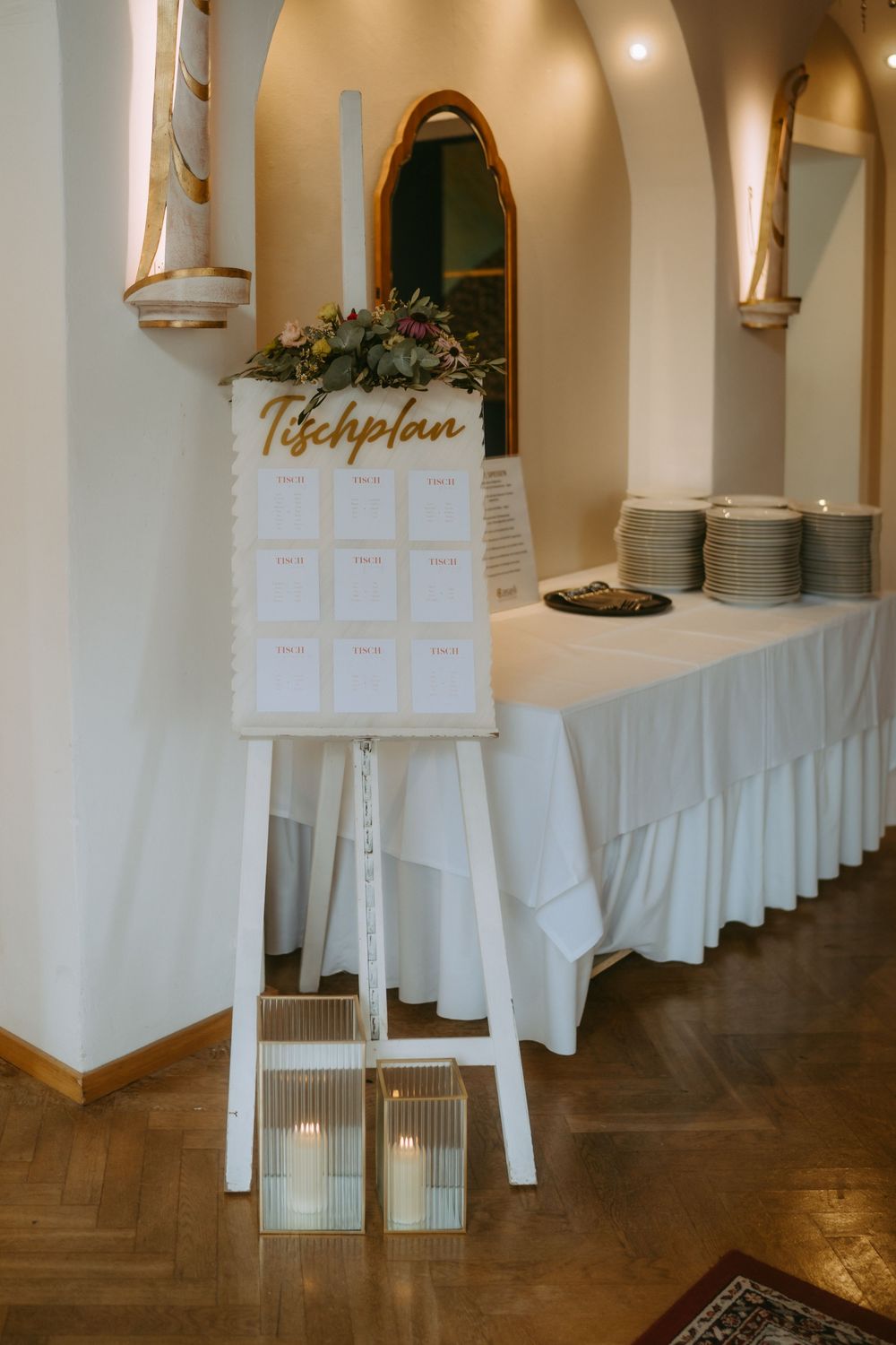 Wedding reception venue with white tablecloths and elegant arched architectural details.