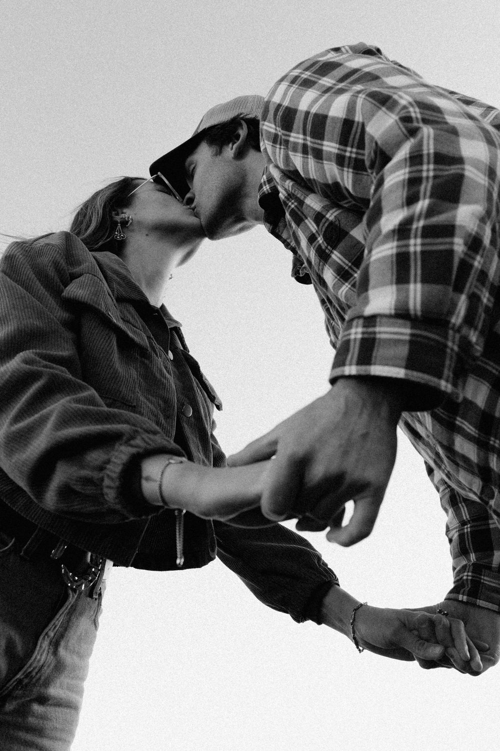 Black and white sequence showing a romantic embrace between two people in a plaid shirt.