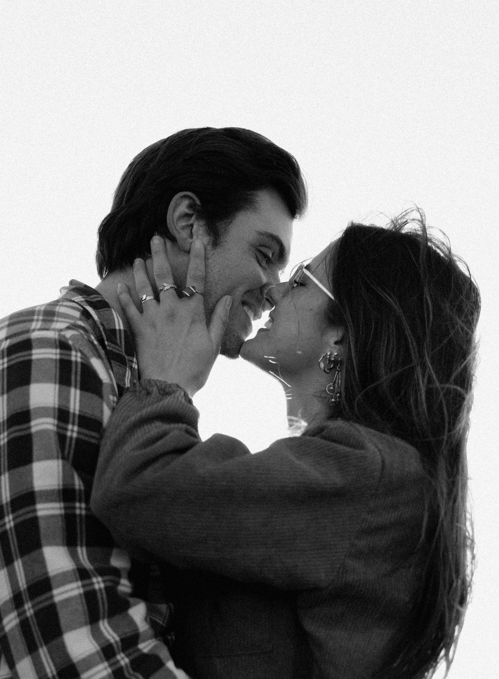 Dramatic black and white series of a couple in a passionate embrace wearing plaid and dark clothing.