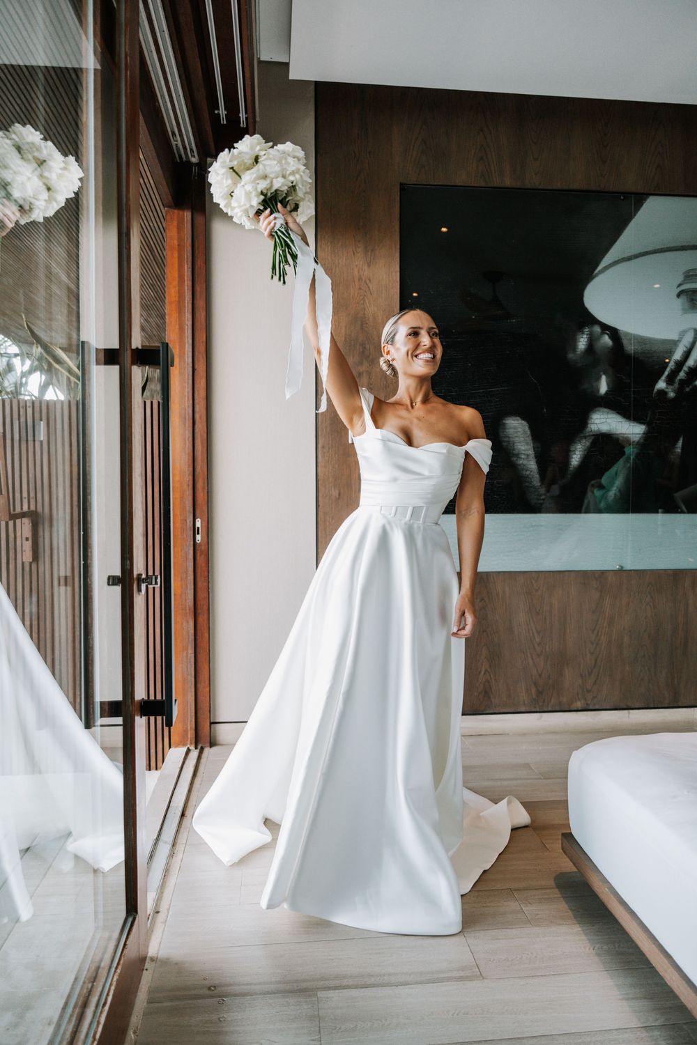 A flowing white wedding dress twirls gracefully in a series of artistic dance-like movements against a modern interior.