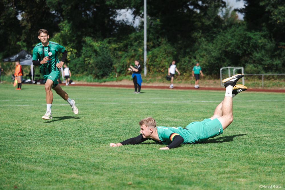 A sequence of soccer goalkeepers diving and practicing save techniques on a grass field during training.