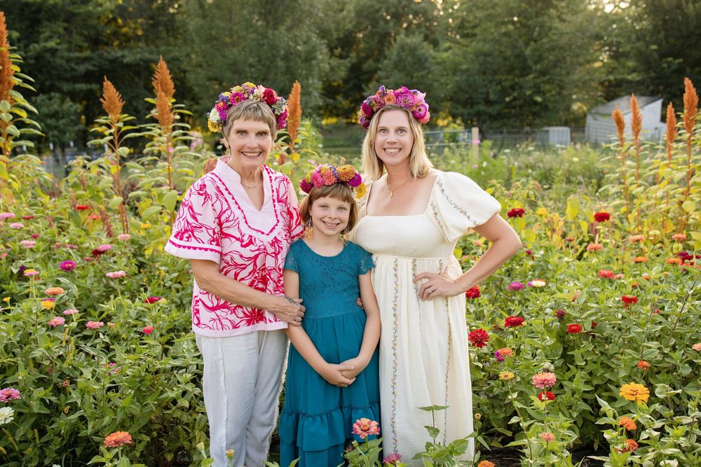 Family smiling together among colorful flowers during summer mini sessions at First Roots Flower Farm in Oconomowoc, Wisconsin.