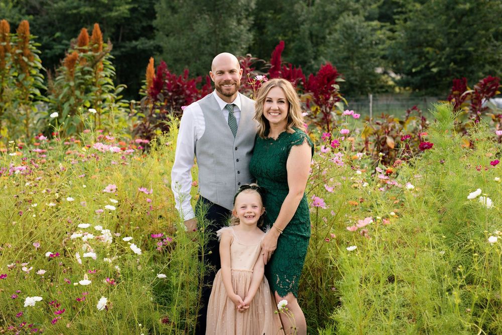 Family smiling together among colorful flowers during summer mini sessions at First Roots Flower Farm in Oconomowoc, Wisconsin.