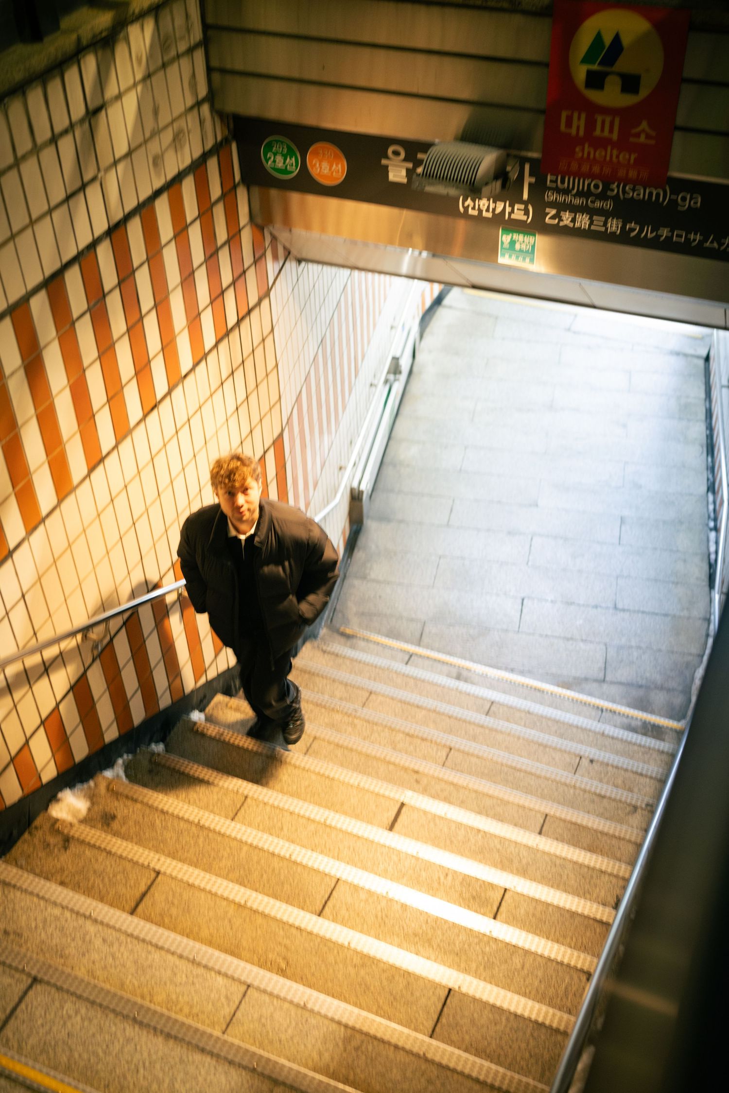 A sequence of photos showing someone descending a tiled stairwell in an underground subway station.