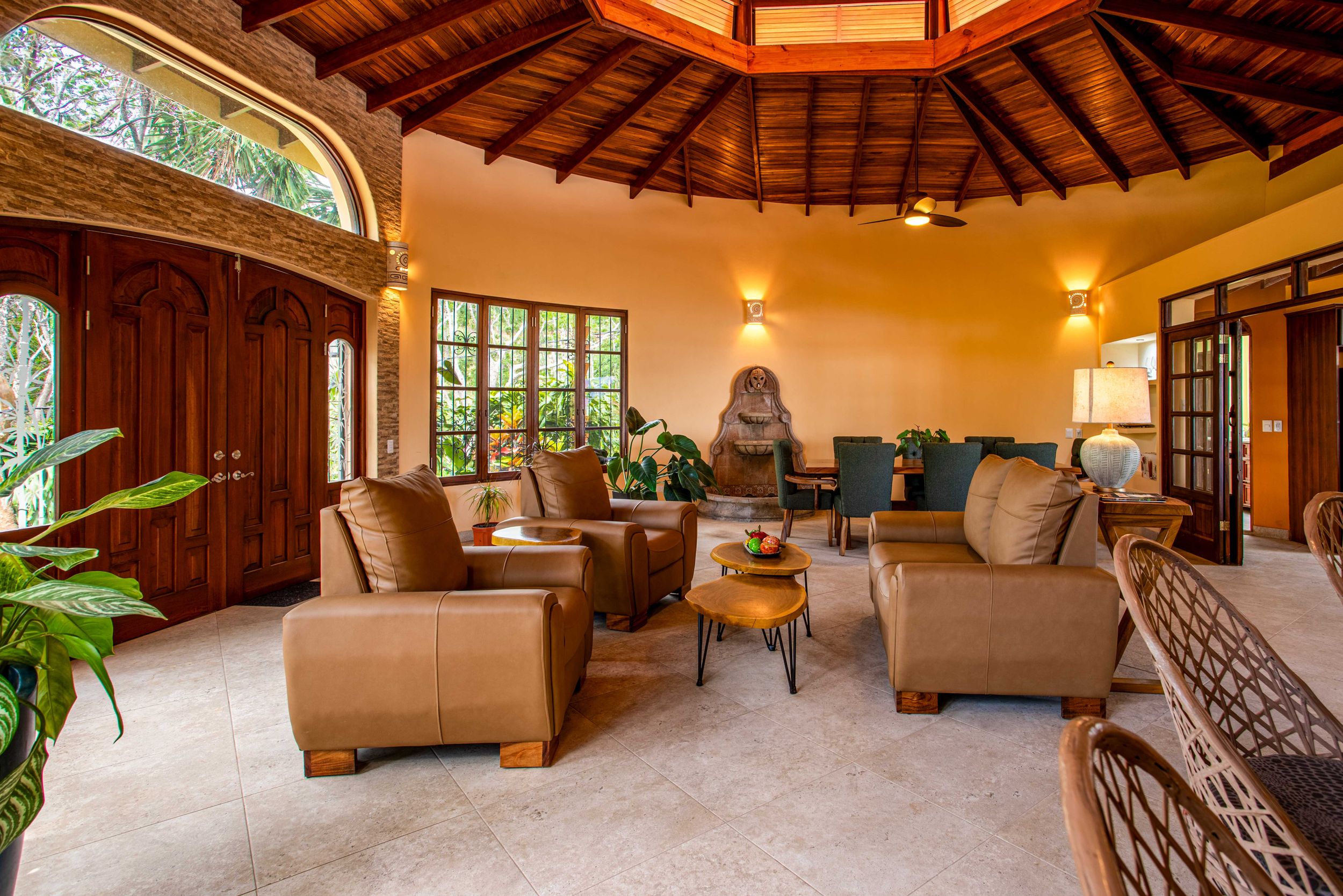 Living room with a wooden ceiling, rustic-style furniture, and large windows overlooking the outdoors