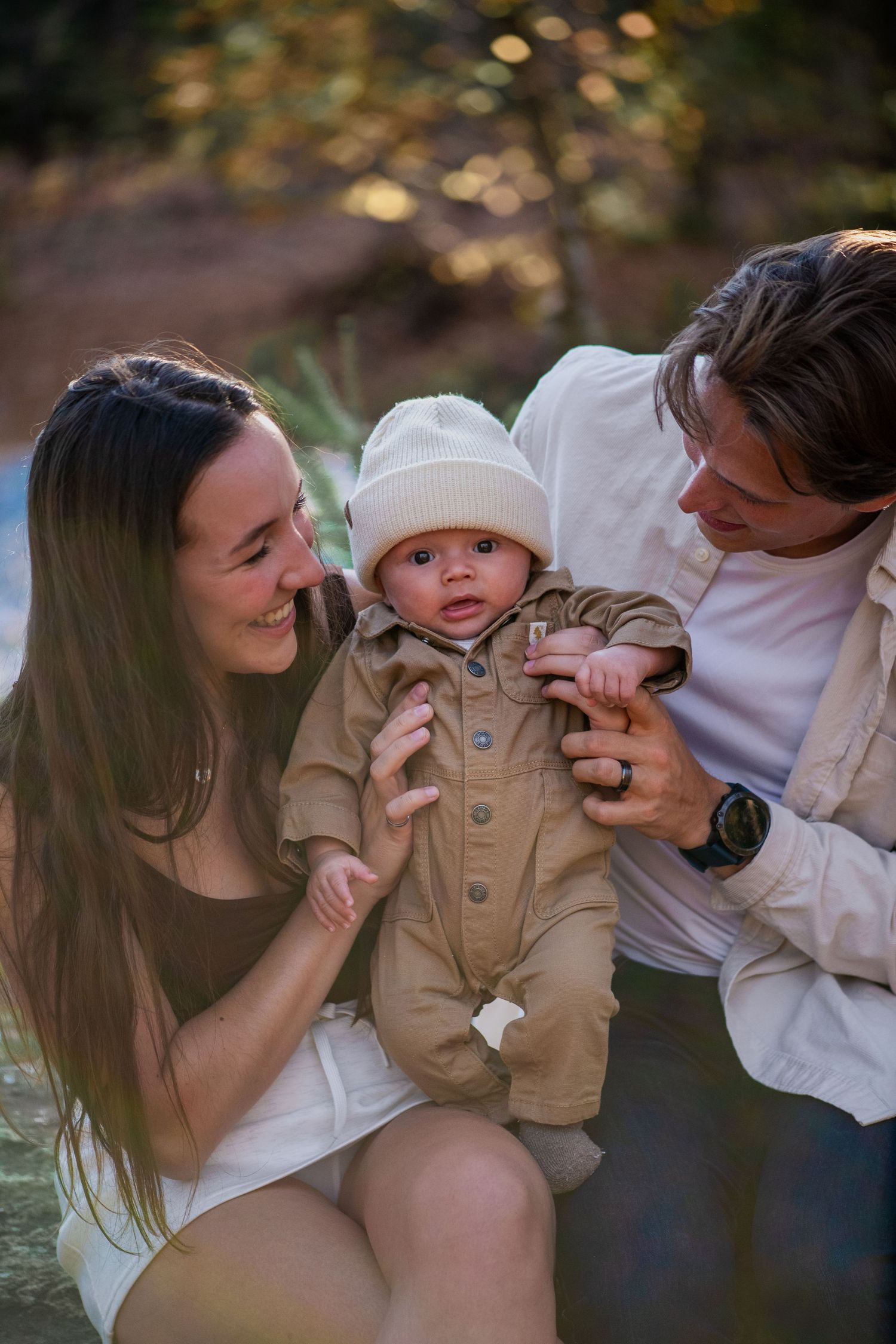 Family walking together on path through dramatic tall pine forest.
