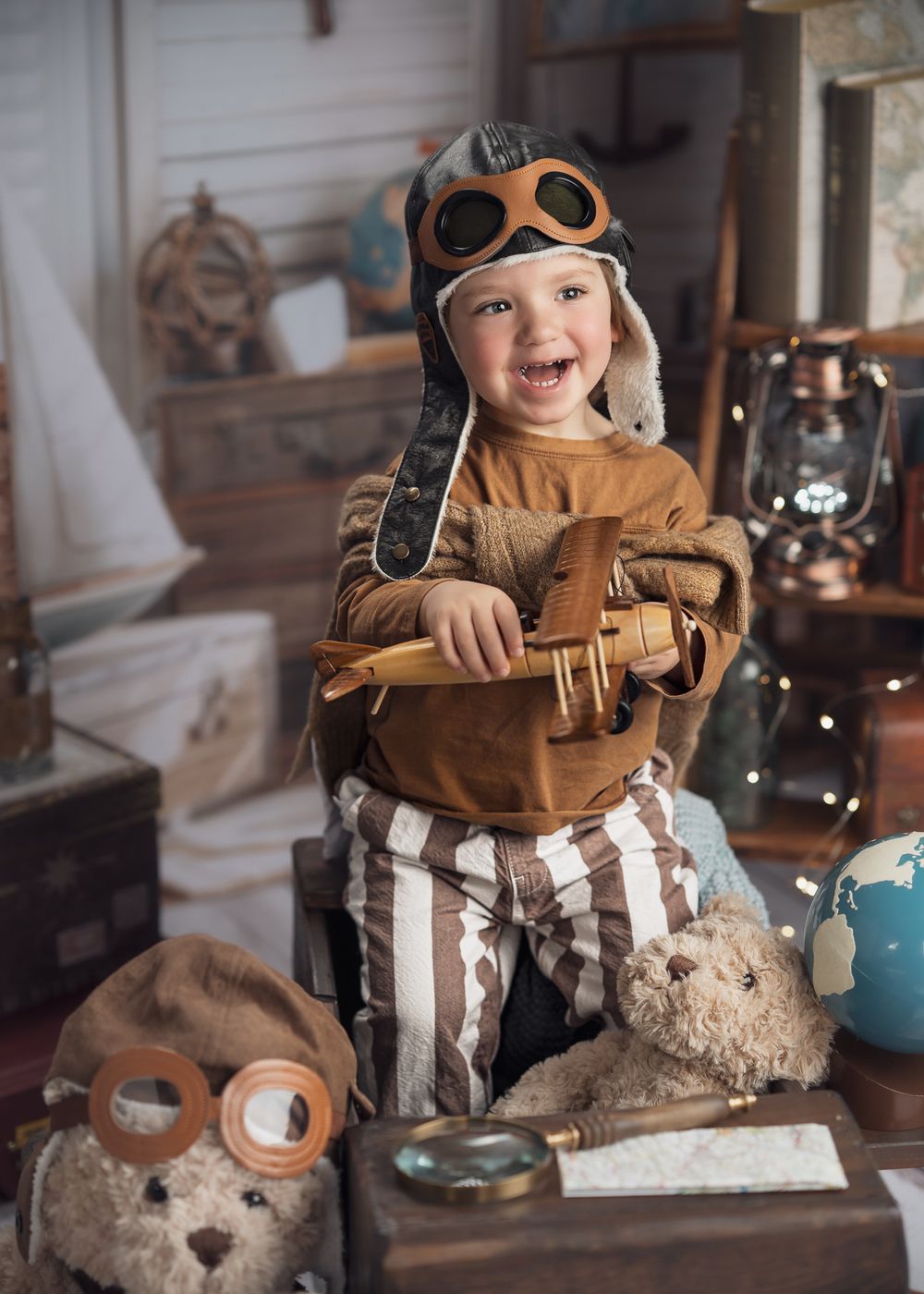 A vintage aviation-themed scene with child in pilot costume surrounded by travel props.