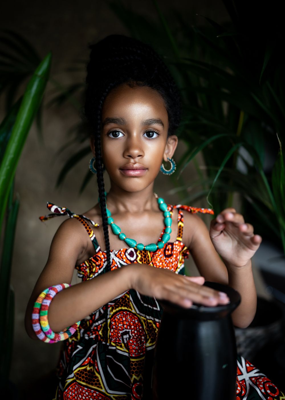 Portrait featuring traditional African-inspired fashion with turquoise jewelry and vibrant prints.