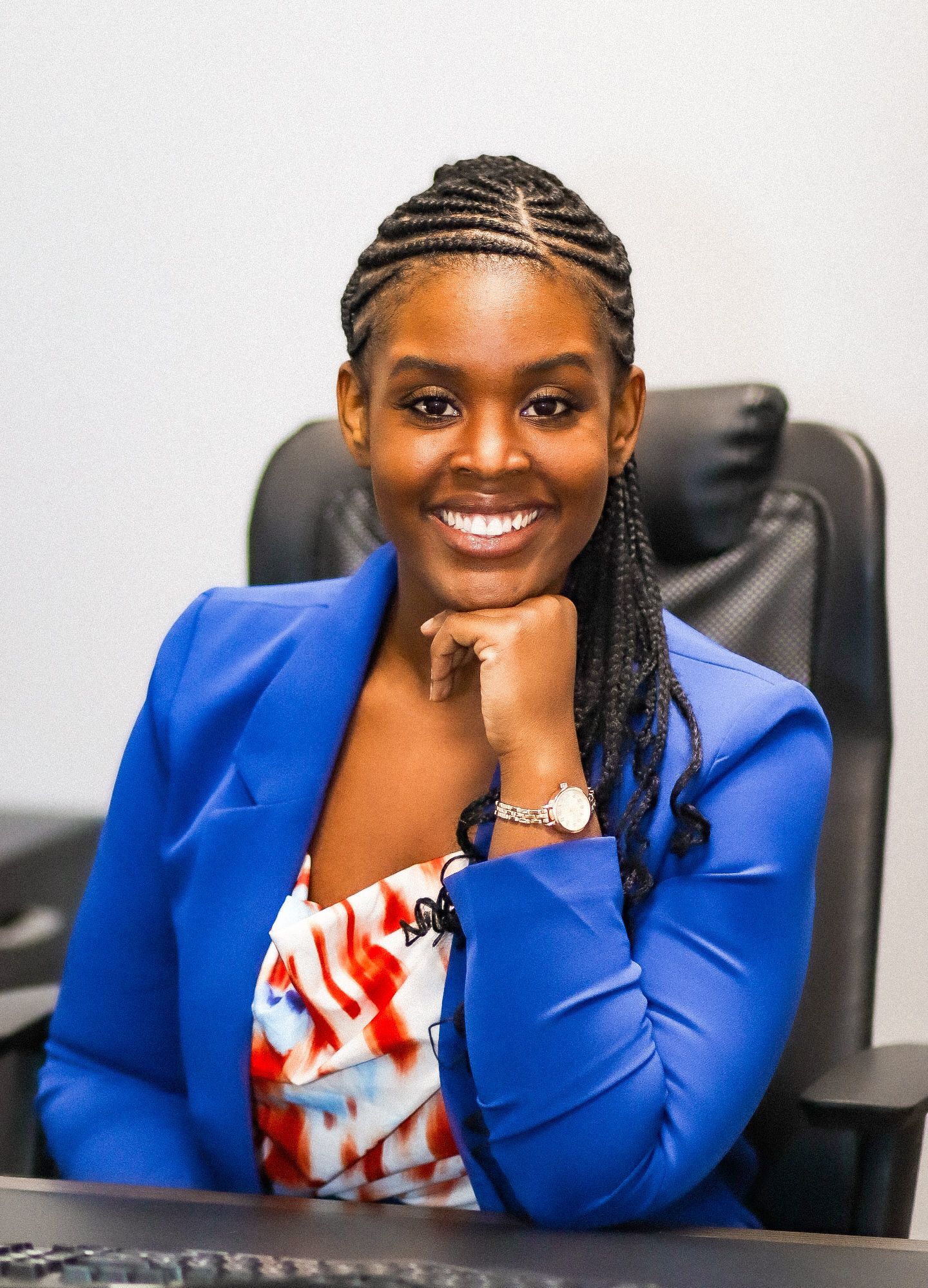 Professional portrait of a business woman in a blue blazer with braided hair.