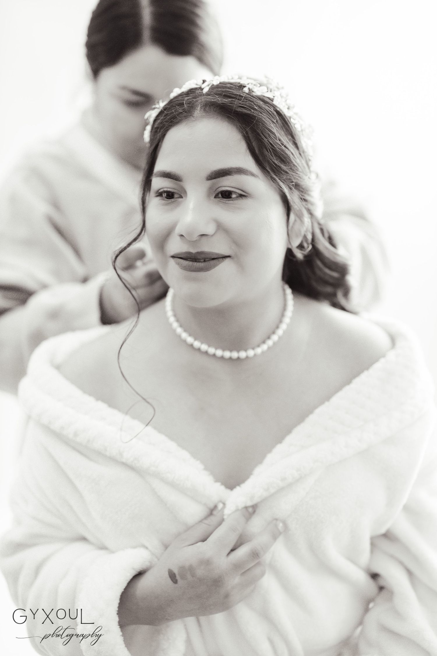 A classic bridal portrait in black and white featuring pearl necklace and elegant hair styling.