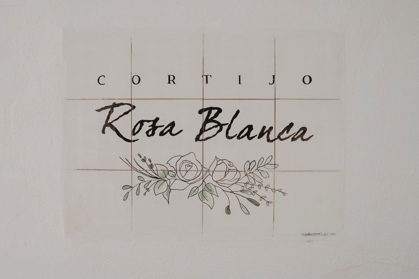 Handwritten text reading 'Cortijo Rosa Blanca' with decorative floral design on white paper.