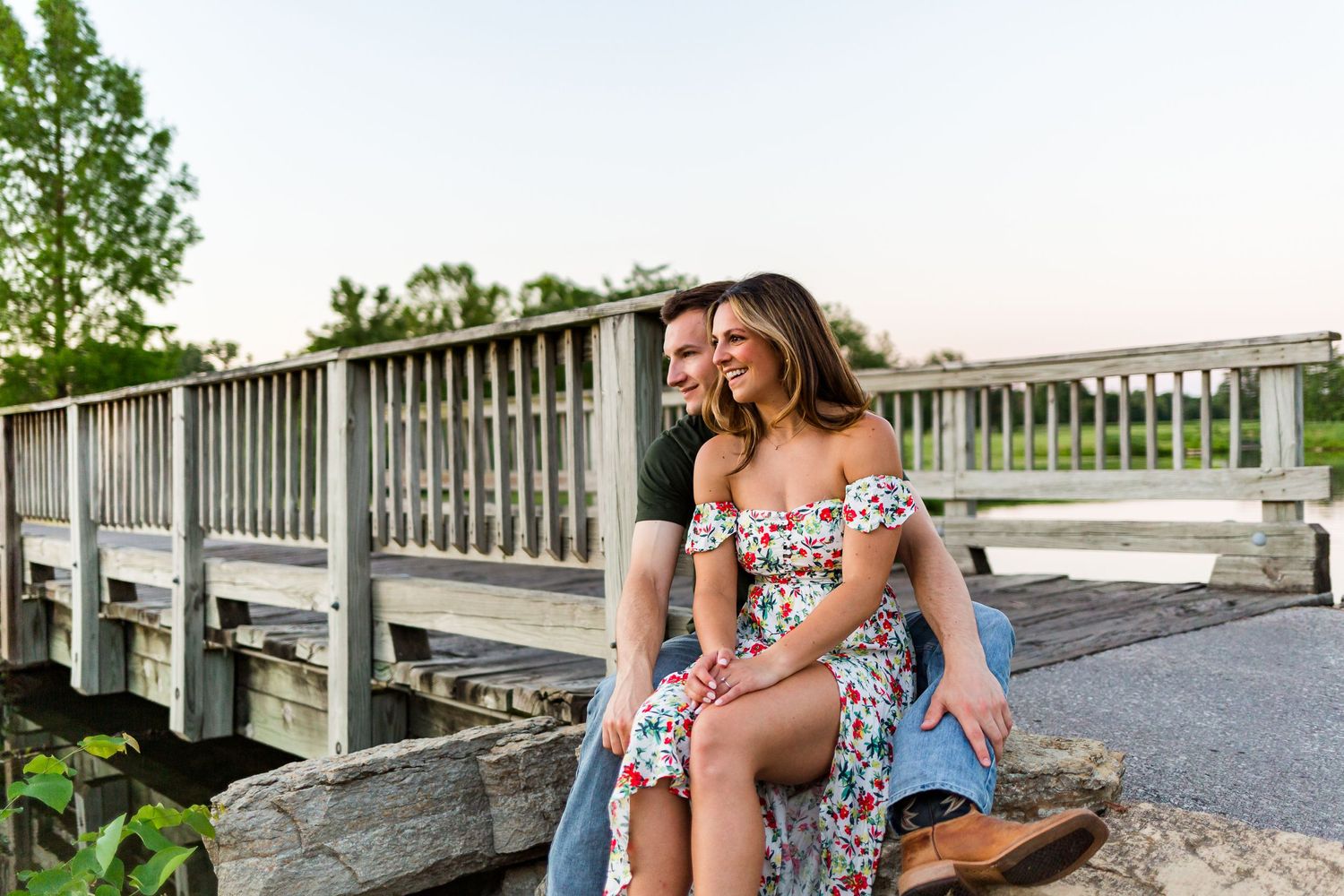 Couple sitting together on a wooden dock during sunset.
