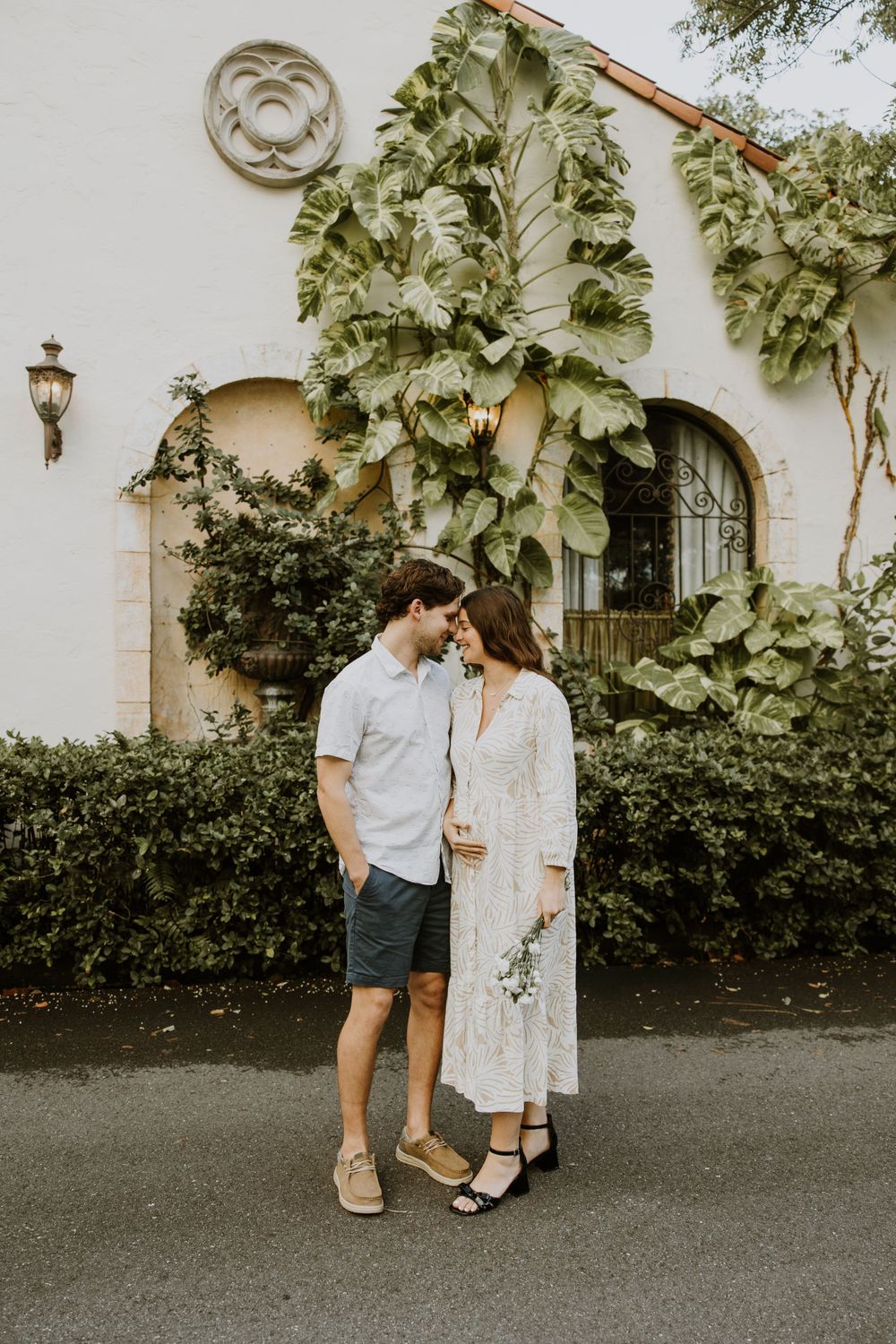 Golden Hour Maternity Session in Palm Beach, Florida captured by Lindsay McDow Photography featuring flowers, foliage, arches, and stairs
