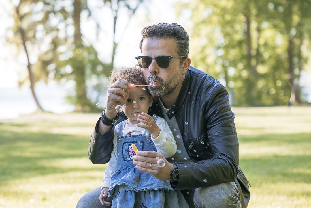 Parent and child share a tender moment while sitting together outdoors.