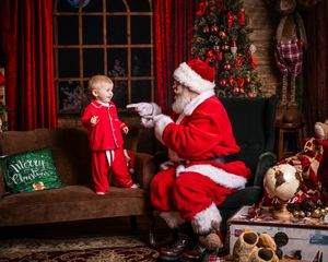 Christmas scene with red pajamas and decorated tree in cozy room setting.