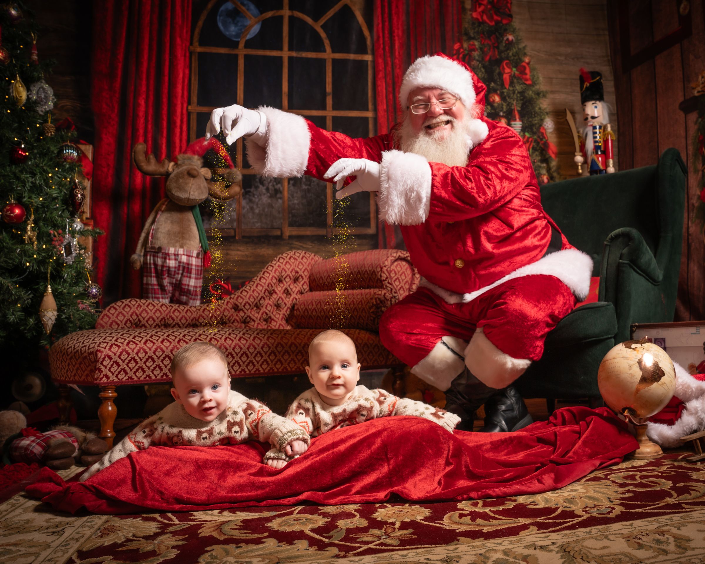 Christmas scene with red blanket and toys in decorated room with arched window.