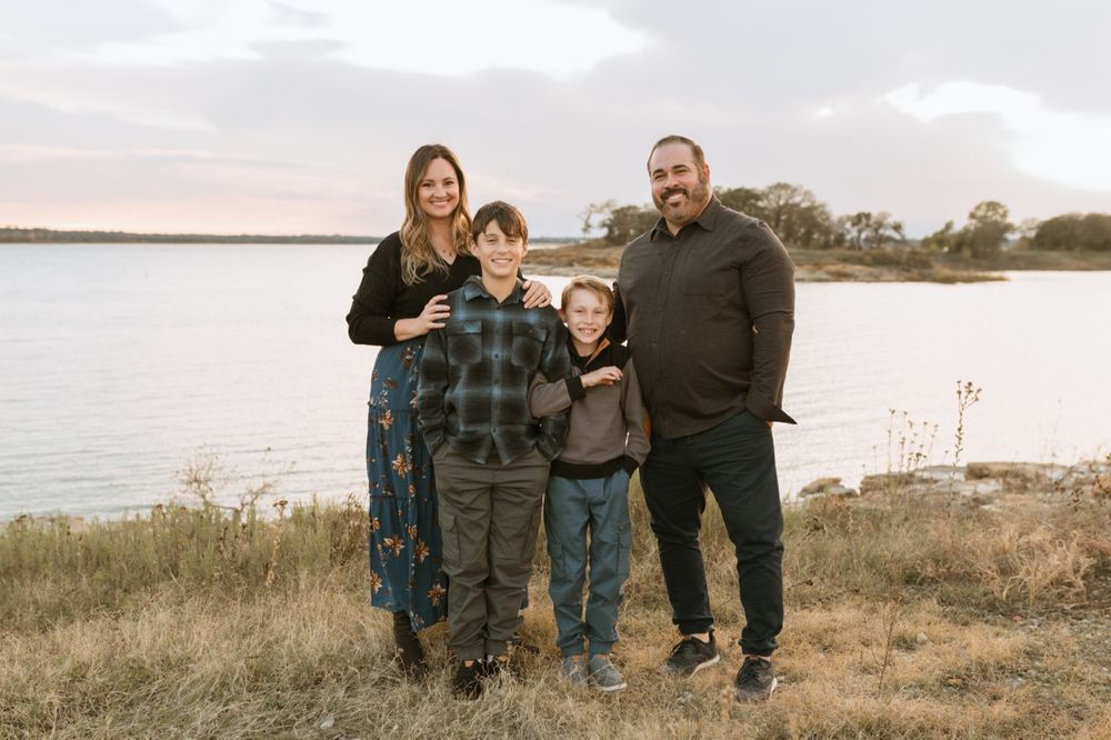 Family enjoying time together by the lakeside on a cloudy autumn day.