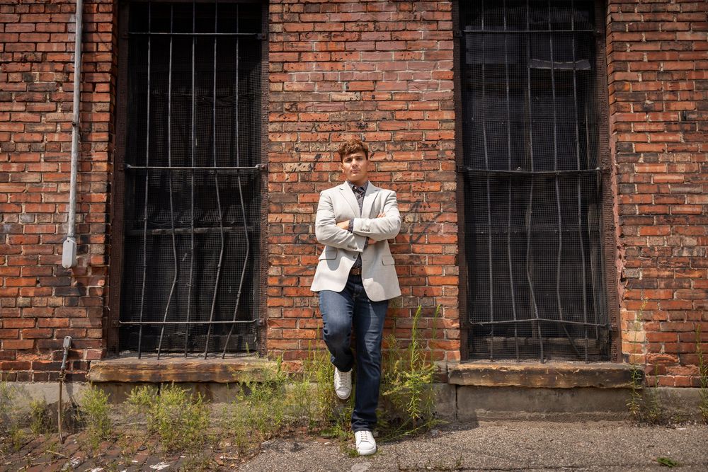 Urban portrait against vintage brick wall with barred windows.