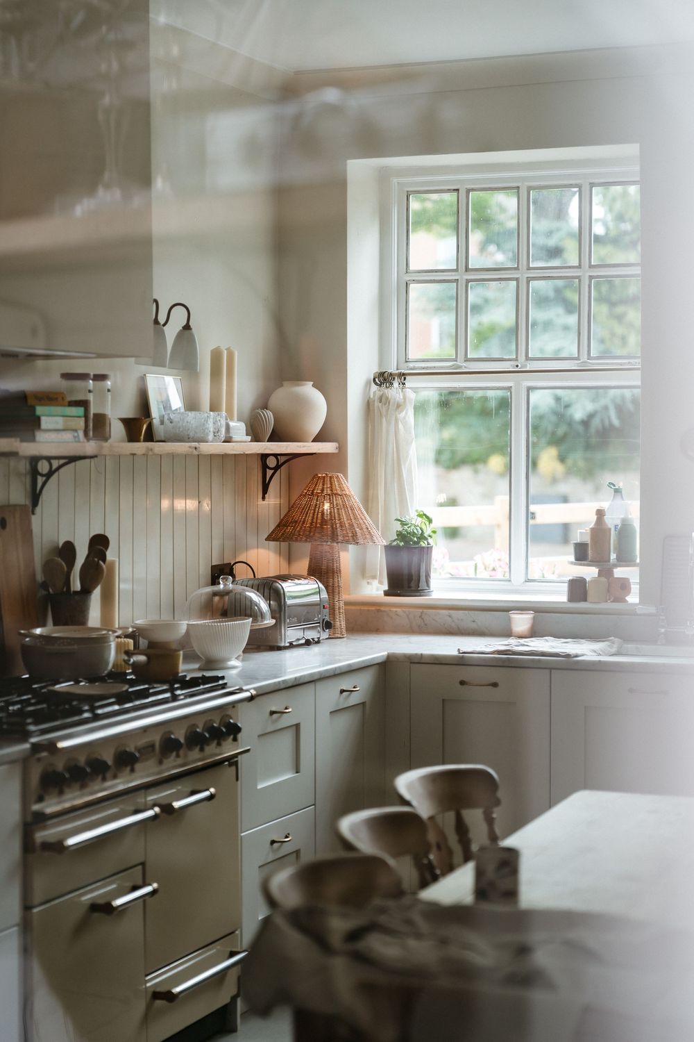 A series of connected images showing a bright white kitchen with modern appliances and natural light from windows.