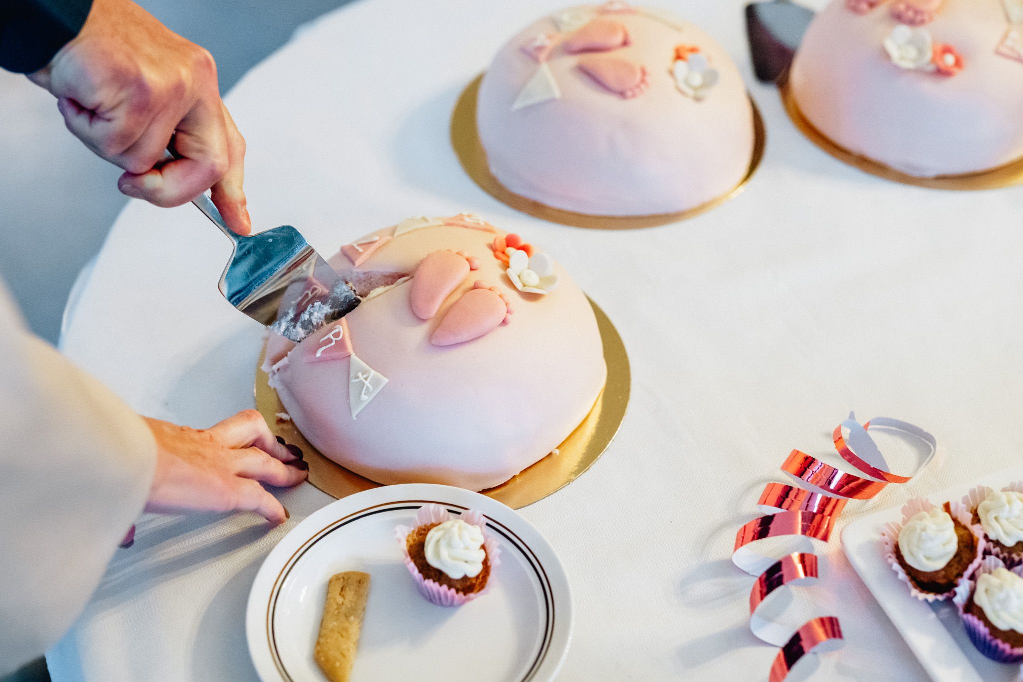 En rosa marsipantårta skärs upp under en dopfest i Linköping.